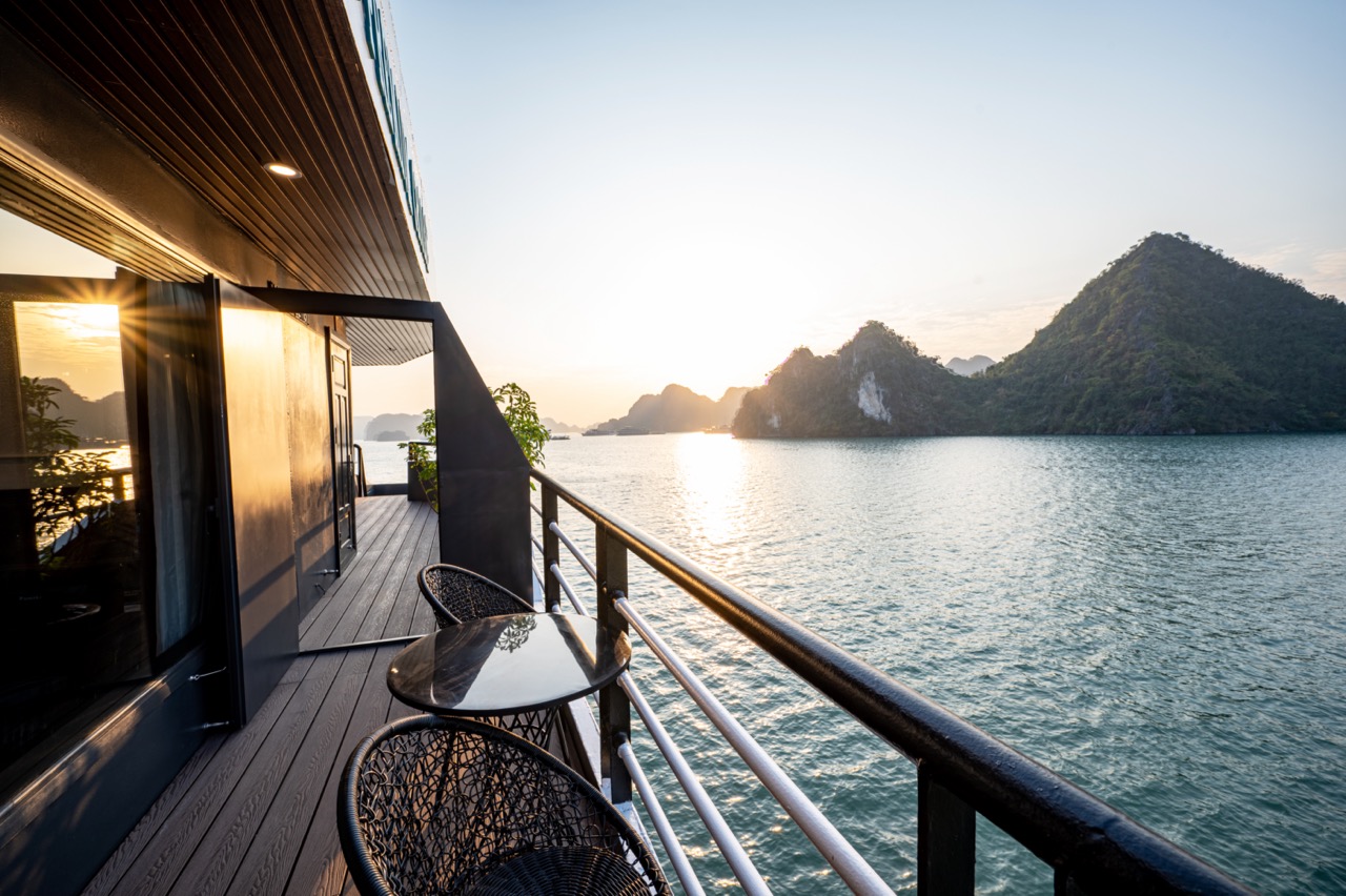 Stunning view from cruise balcony overlooking Halong Bay at sunset, peaceful and scenic travel exper.