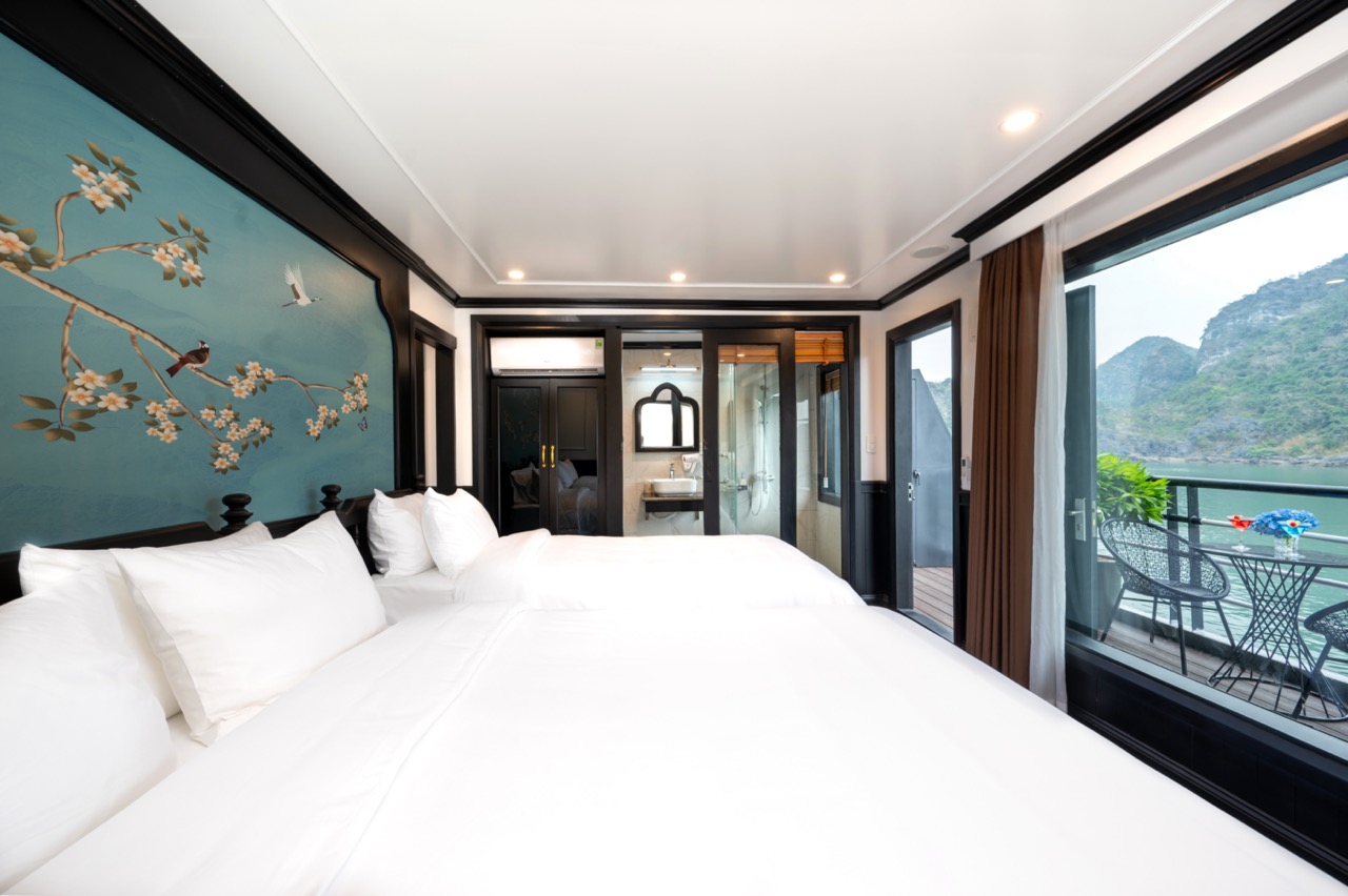 Elegant cruise balcony room overlooking Lan Ha Bay with scenic mountain views, perfect for relaxing.
