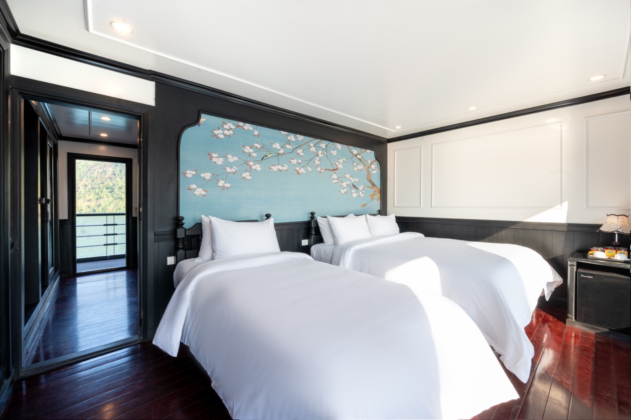 Elegant cruise balcony with twin beds overlooking Lan Ha Bay, perfect for relaxing and enjoying scen.