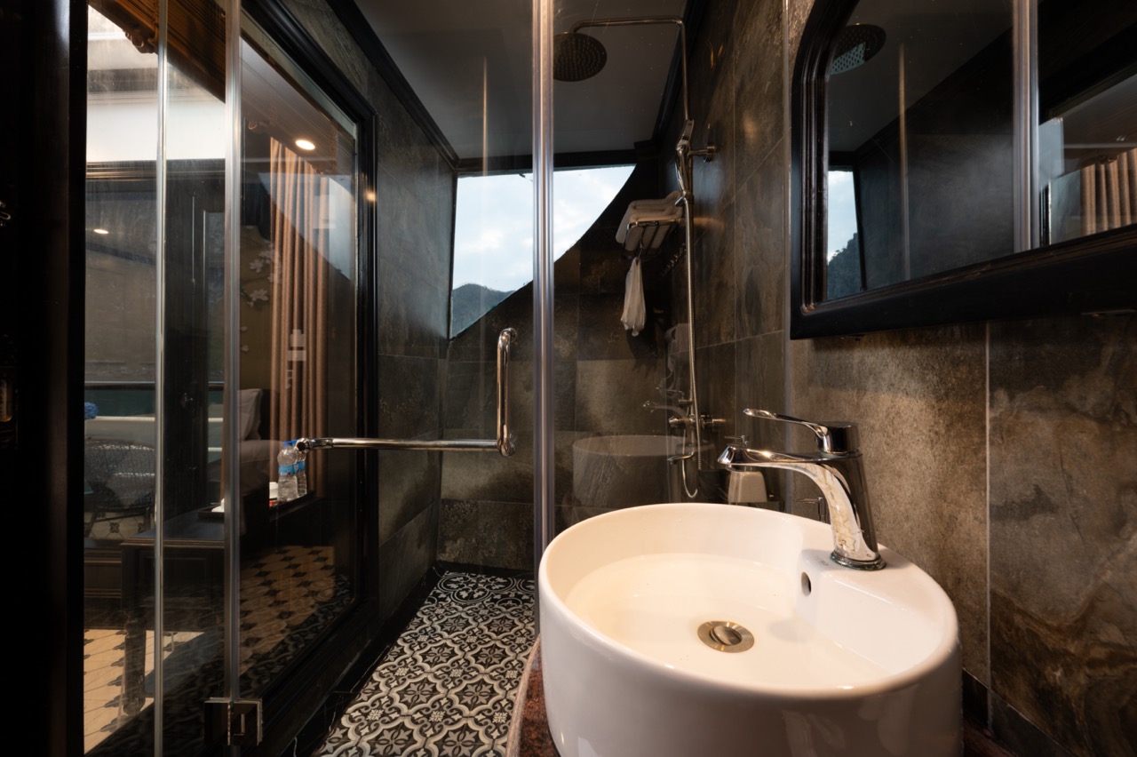 Luxurious cruise bathroom with modern fixtures and scenic views of Halong Bay. Perfect for a relaxin.
