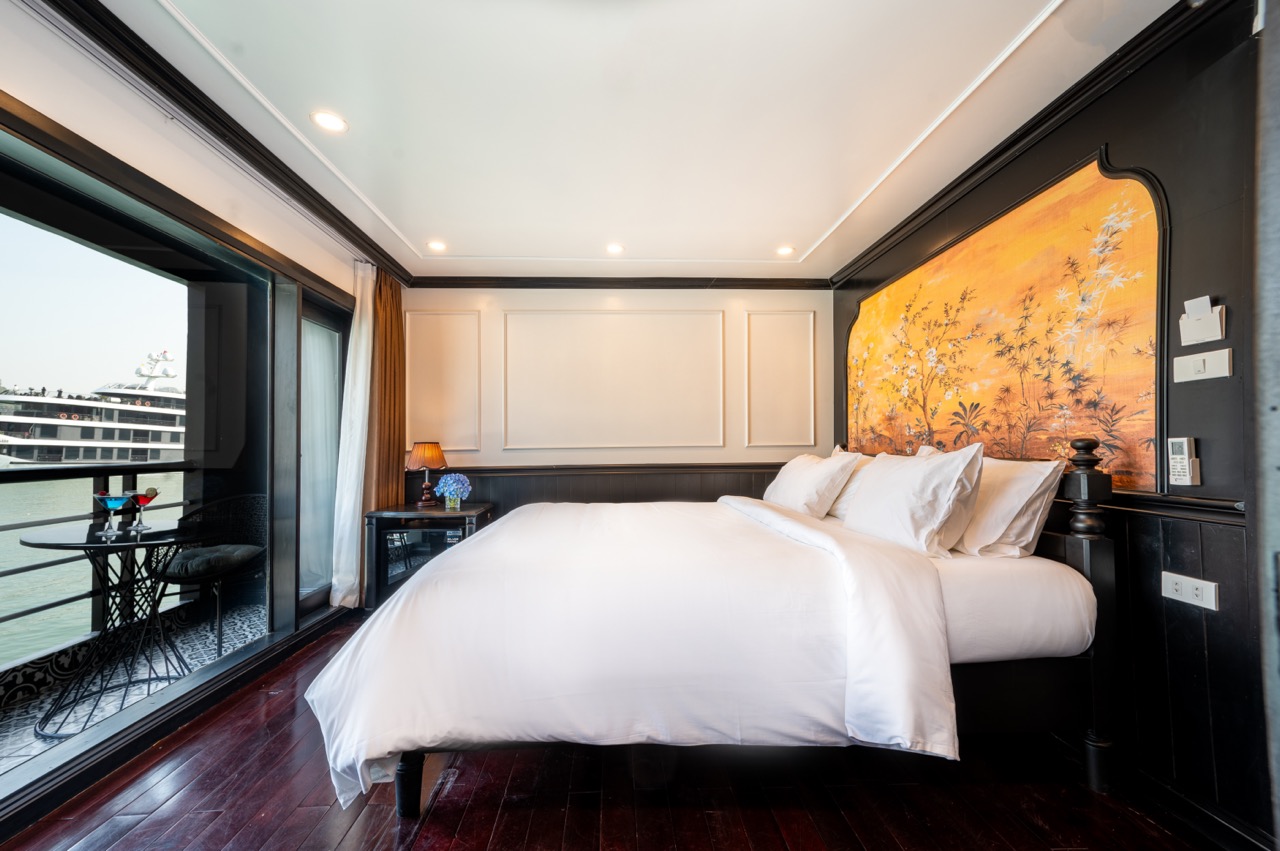A luxurious cruise room with a balcony offering stunning Lan Ha Bay views, ideal for a peaceful geta.