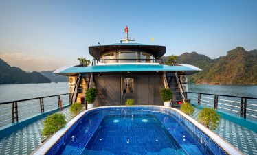 Luxury Lan Ha Bay cruise with private pool, scenic mountain backdrop, and relaxing atmosphere.