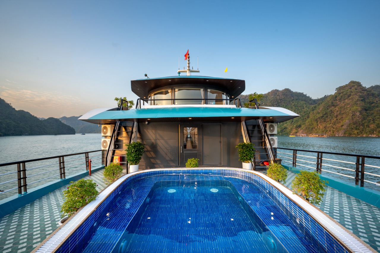 Luxury Lan Ha Bay cruise with private pool, scenic mountain backdrop, and relaxing atmosphere.