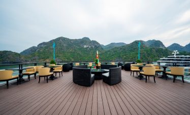 Spacious cruise balcony overlooking Lan Ha Bay with scenic mountain backdrop, ideal for leisure.