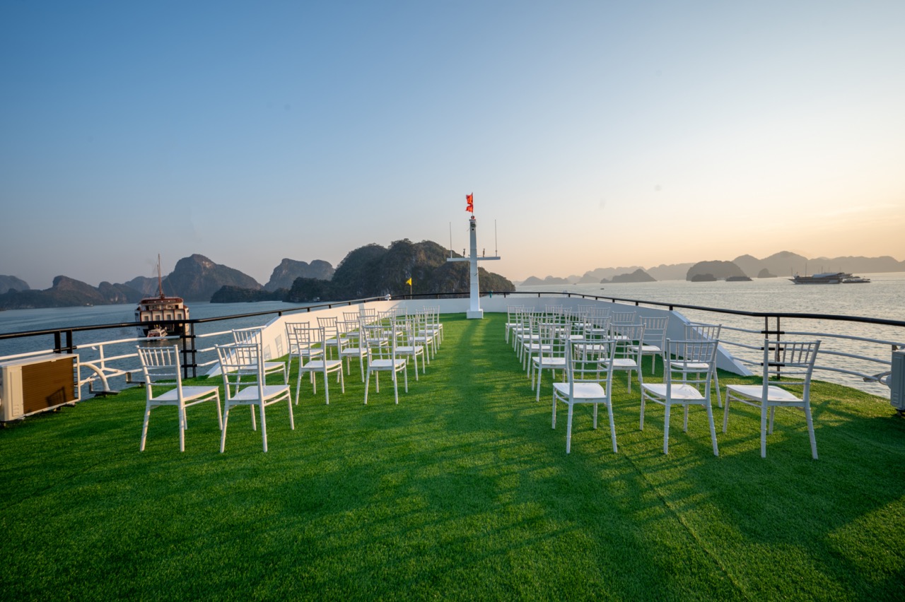 Beautiful Lan Ha Bay cruise balcony with seating and ocean scenery at sunset, perfect for relaxing a.