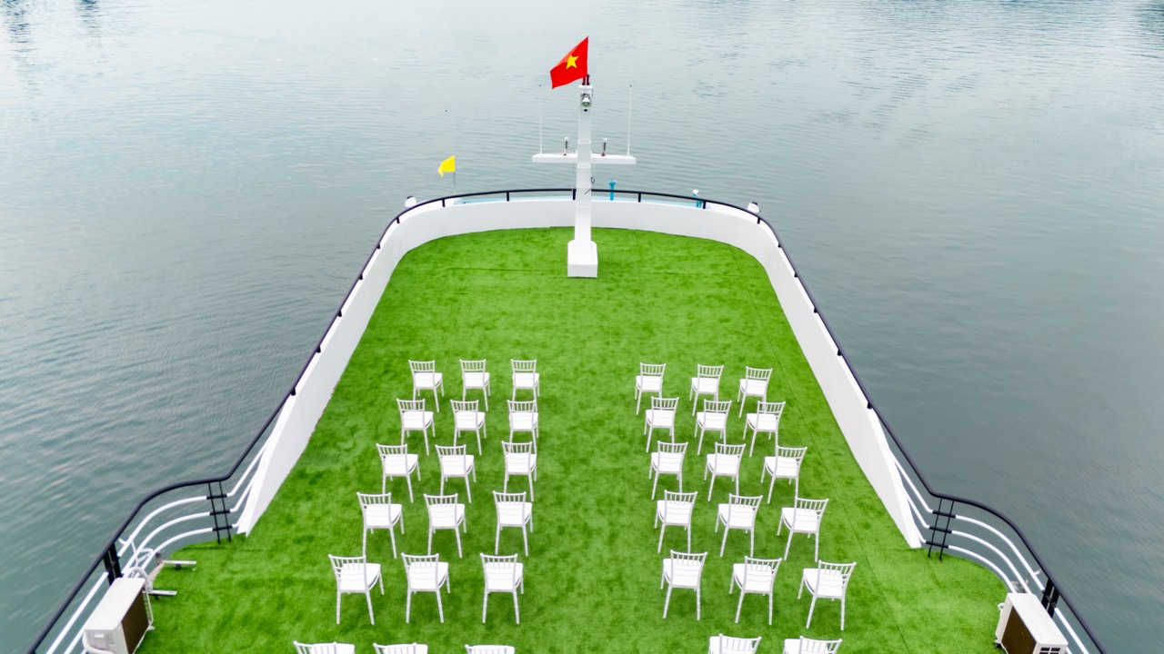 Beautiful Lan Ha Bay cruise deck with seating area and flag, perfect for relaxing and enjoying the v.