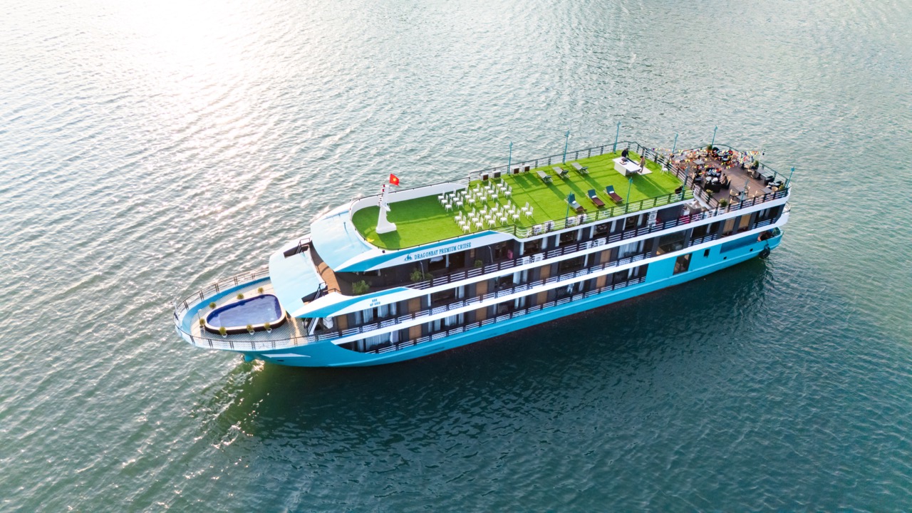 Aerial view of a luxury cruise in Lan Ha Bay with outdoor deck, sun loungers, and calm waters, perfe.