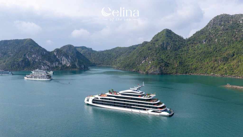 Large white luxury cruise ship in a calm turquoise bay with green, steep cliffs in the background. logo: Celina of the Sea at top center.