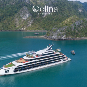 Large white luxury yacht cruising through turquoise water near green, rocky islands; Celina of the Sea logo above.